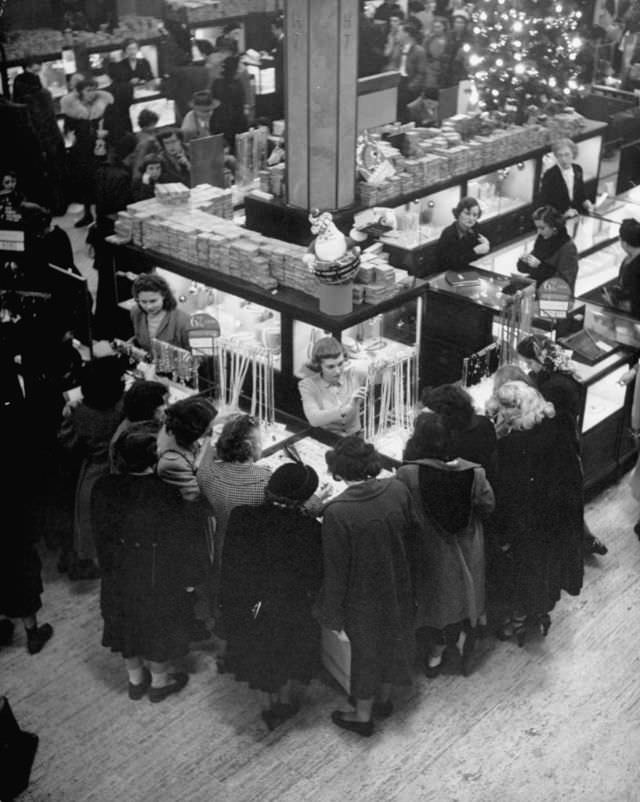 Customers crowding around a counter of imitation pearls.