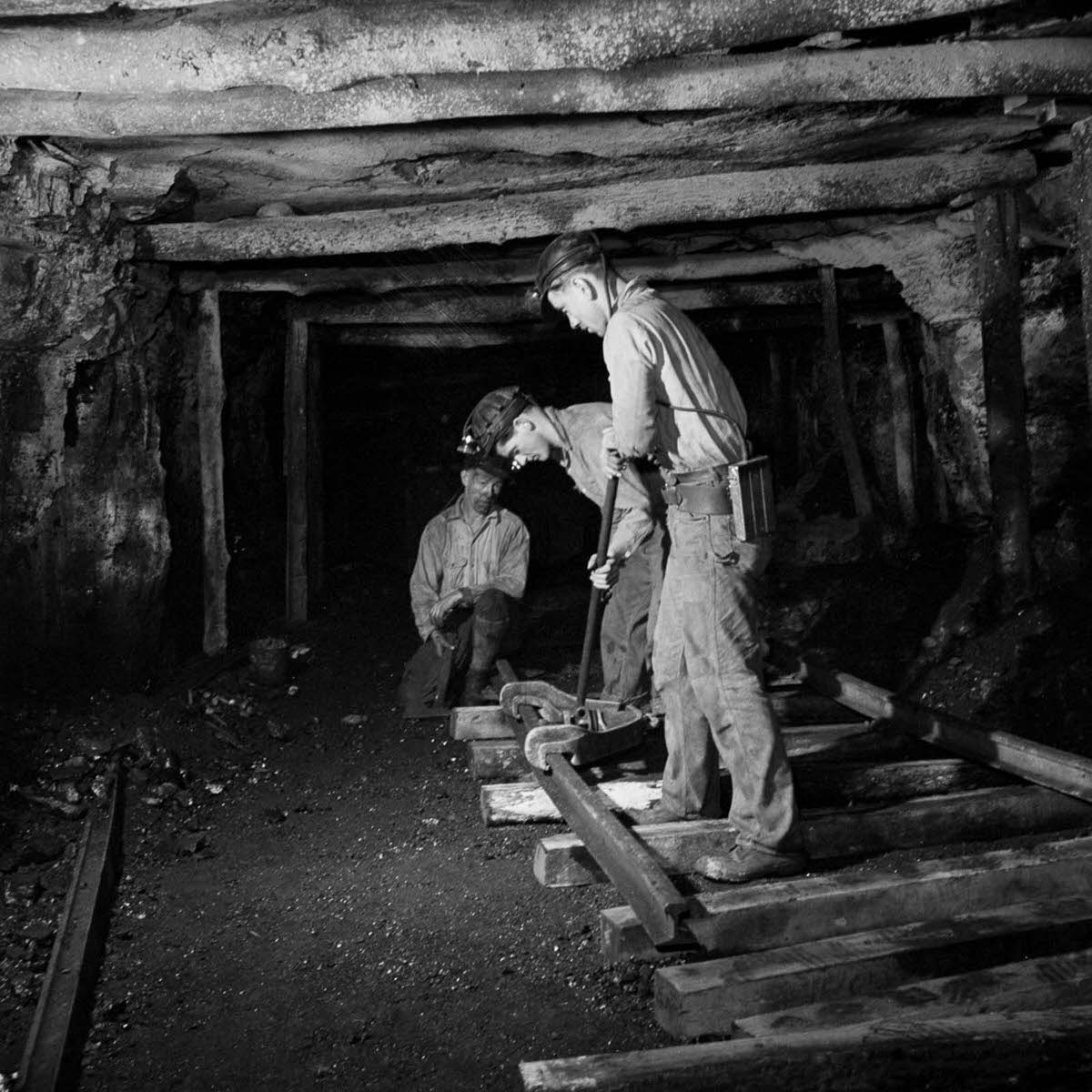 Miners lay track for machinery.