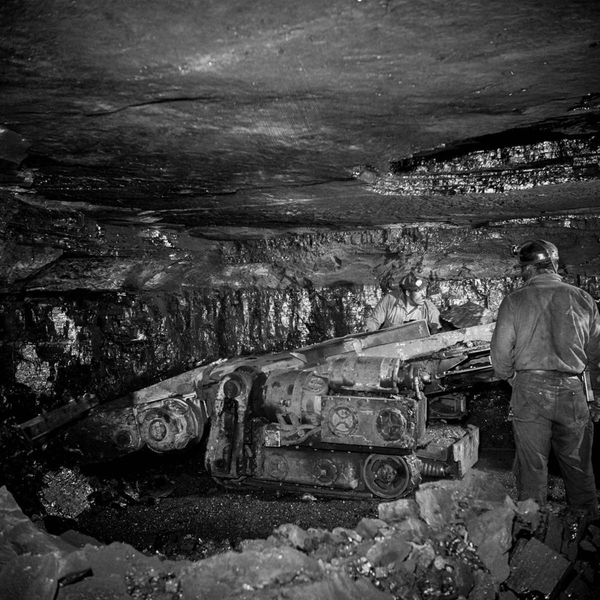 Miners operate a machine for gathering coal.