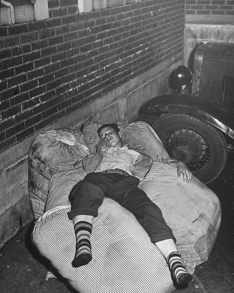 A boy sleeping while waiting for the bus to arrive in the depot, Salt Lake City, 1945.