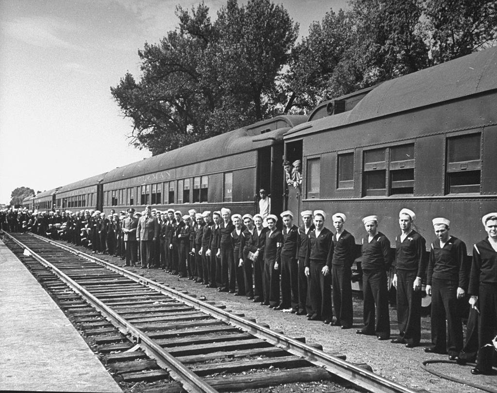 Navy men standing in front of the Pullman train that was just released to the military from civilian run.