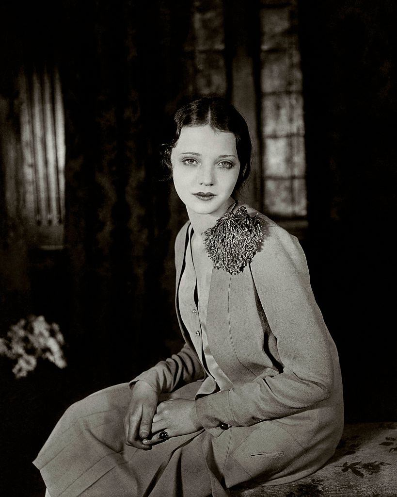 Sylvia Sydney wearing a light dress, with a pom-pom on the left shoulder, looking with dreamy eyes, 1927.