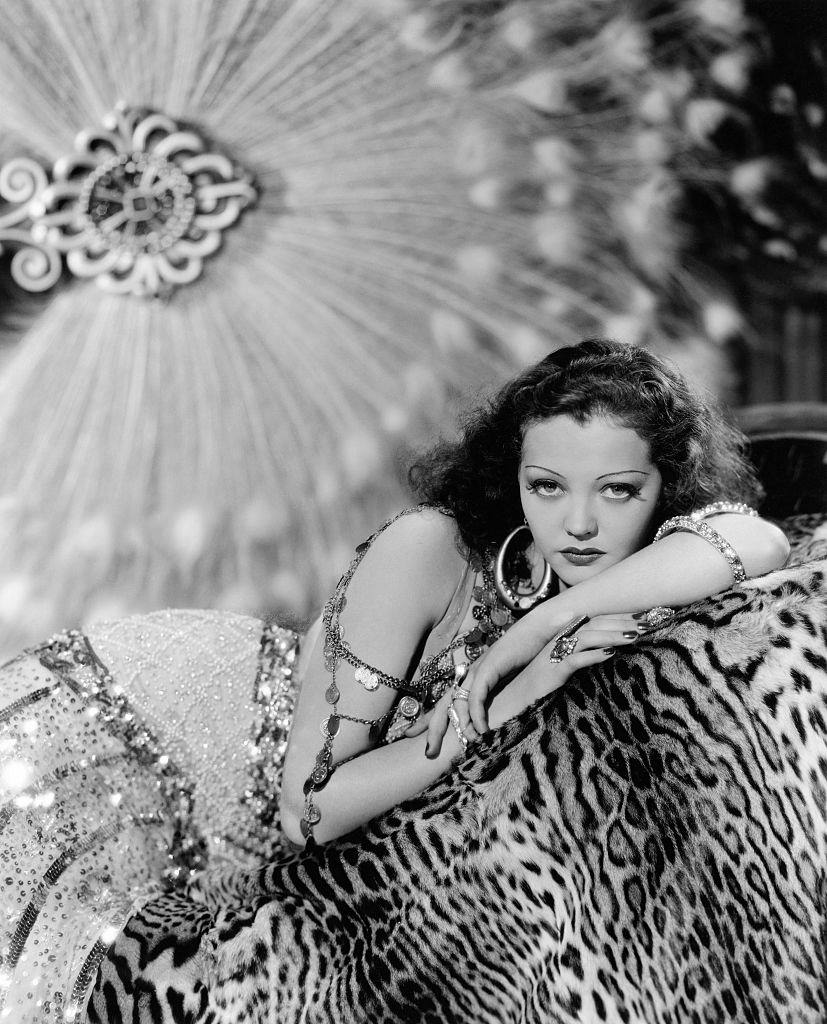 Sylvia Sidney reclines on a leopard skin, dressed for the role of Lillie Taylor in the 1934 film 'Good Dame'.