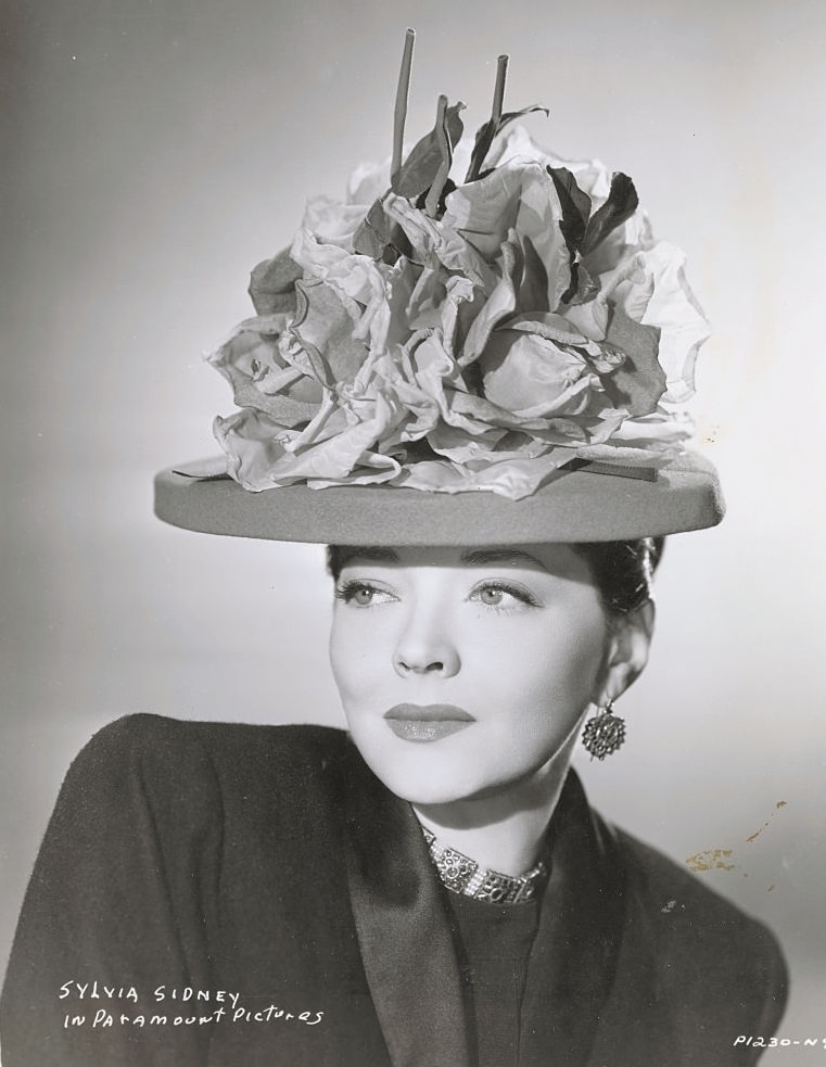 Sylvia Sidney wearing hat made with paper flowers, 1946.