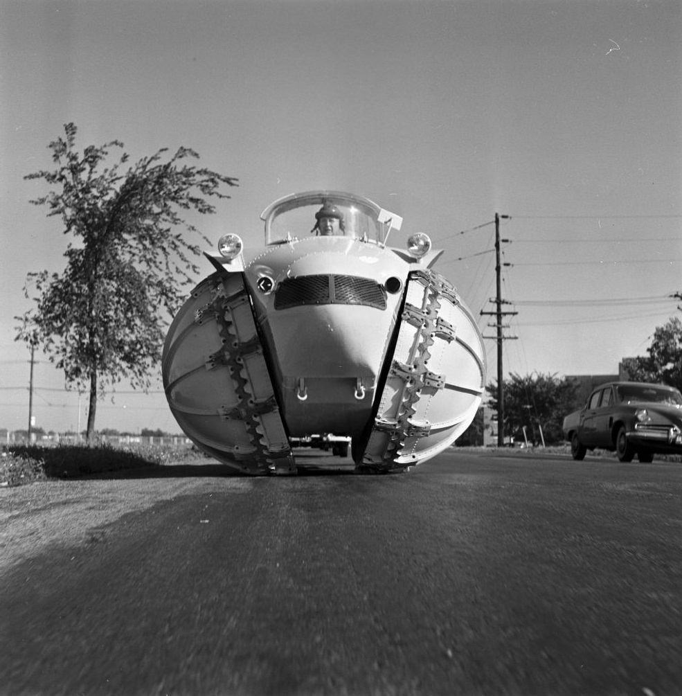 Man driving four-wheel vehicle 'Rhino' with hemispheric wheels.