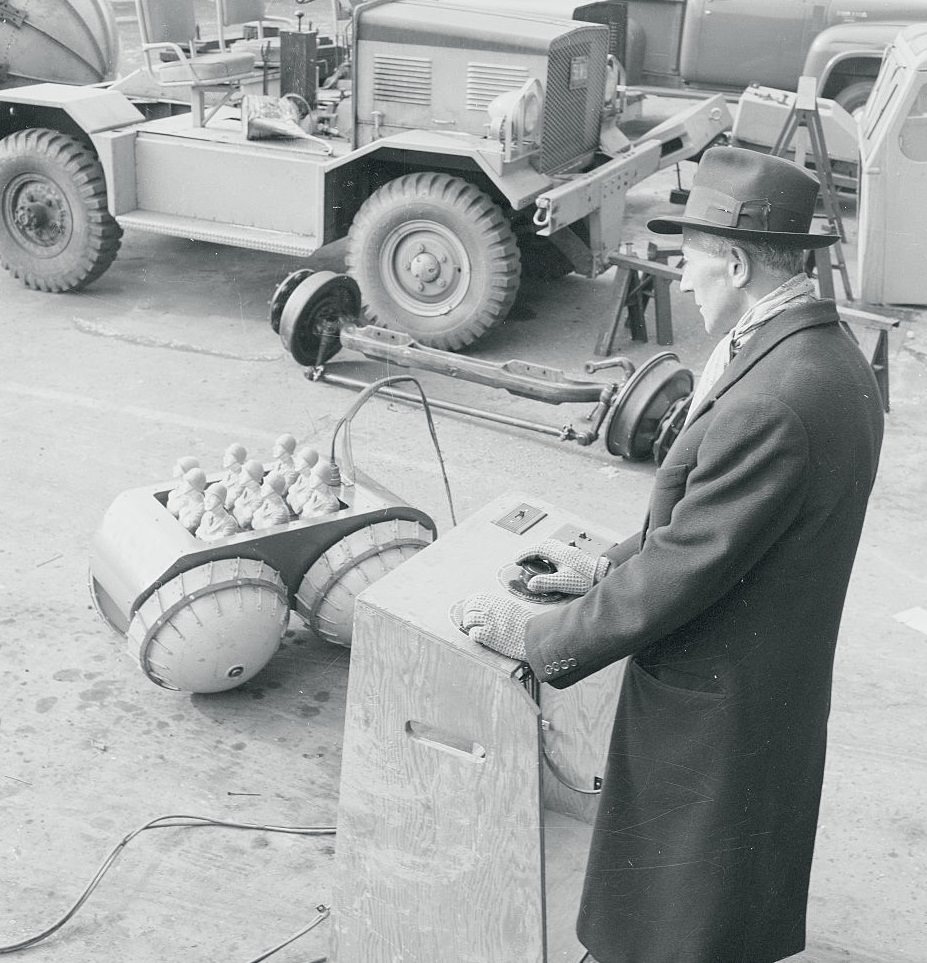 Elie P. Aghnides, demonstrating his invention 'Baby Rihno' at Marmon-Herrington Co. Inc.