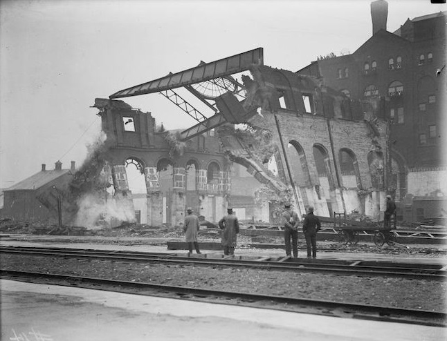 Men viewing the demolition of fire remains at site of future Union Station.