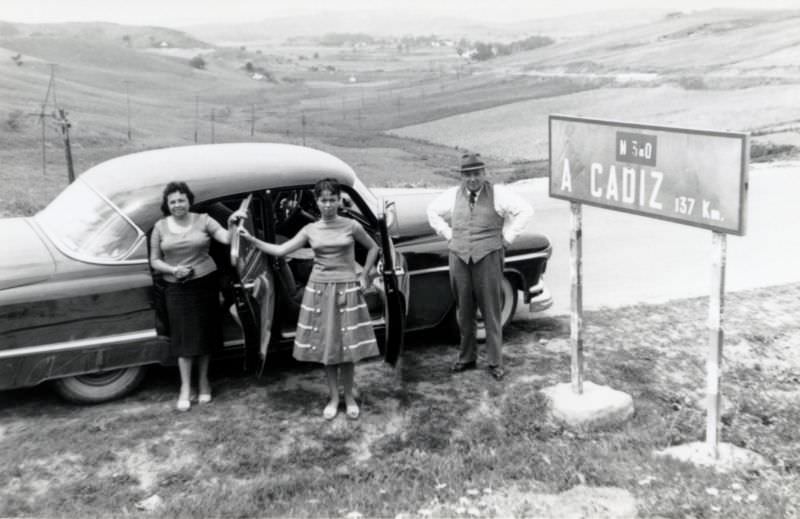 Three members of a Spanish middle-class family posing with a 1952 Oldsmobile 98 on N-340, the highway running along Spain's southern coastline from Barcelona to Cádiz, 1955
