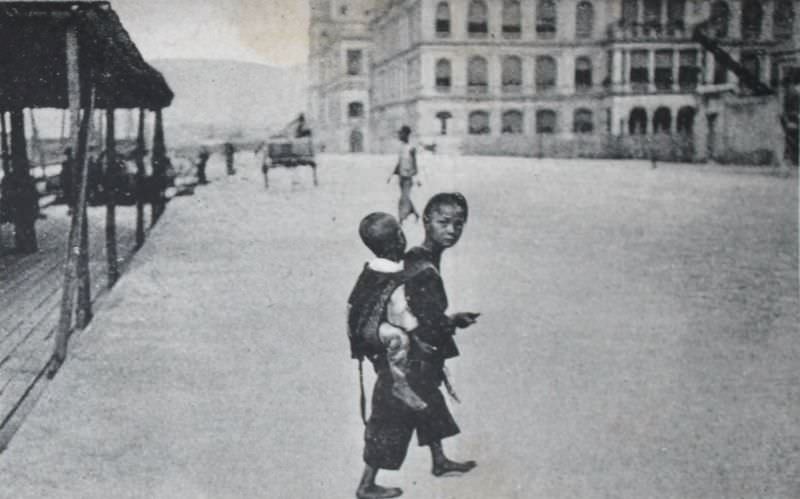 Praya Central, showing how Chinese child is carrying another child, Hong Kong