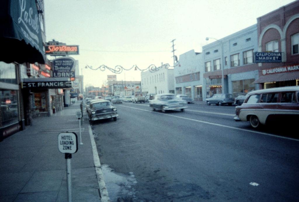 Cars driving on Lake Street as the famous Reno sign "Biggest little City in the World!" is off in the distance December, 1958.