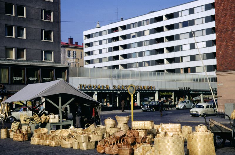 Bags and baskets stand outside of a market stall in a neighbourhood market in Helsinki, 1968