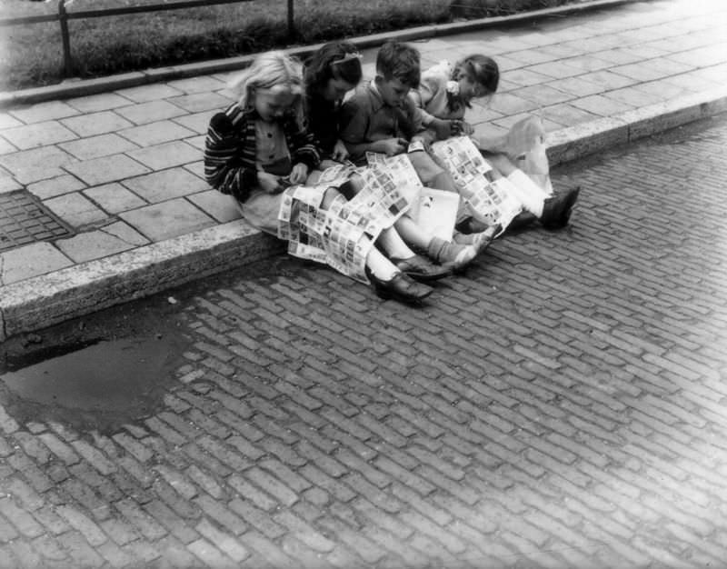Children on the sidewalk with large sheets of advertising stamps, July 9, 1947