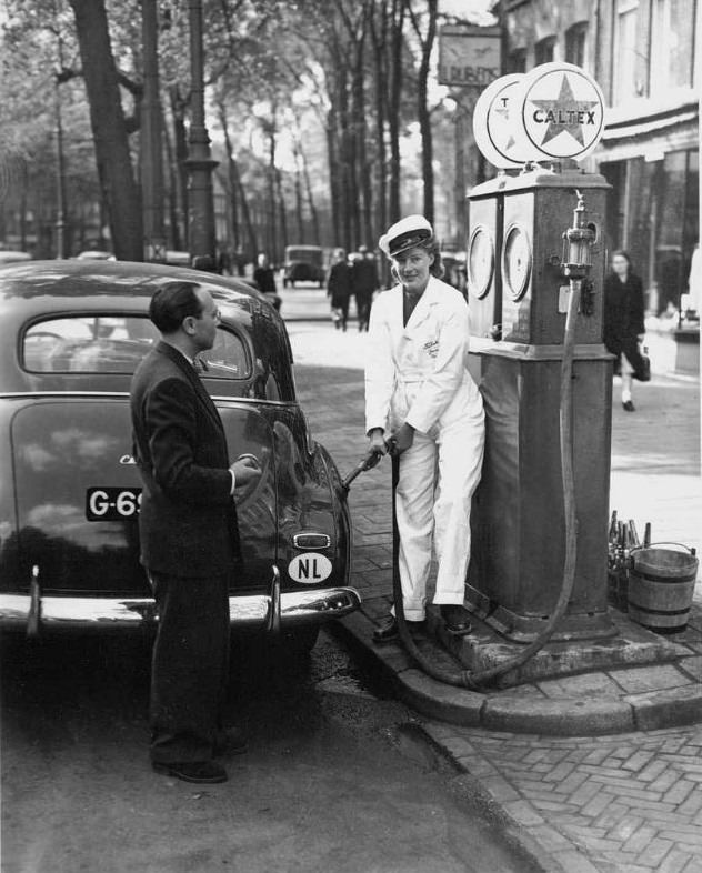 Female service at the gas station of garage Tobacco, Nieuwezijds Voorburgwal. Amsterdam, September 22, 1947