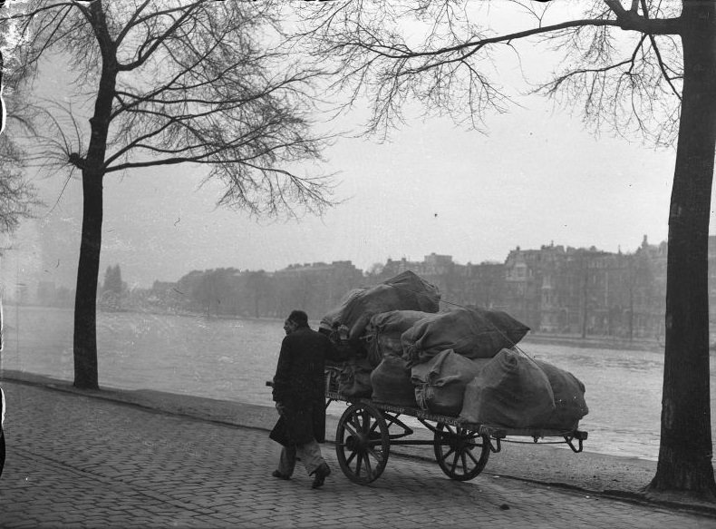 Two men with a handcart loaded with old paper from the material service of the Hulp voor Onbehuisden, Weesperzijde. Amsterdam, November 18, 1947