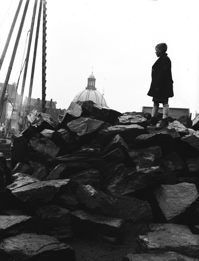 Boy on basalt blocks. The sheeting at the Central Station will be repaired. Amsterdam, April 24, 1946