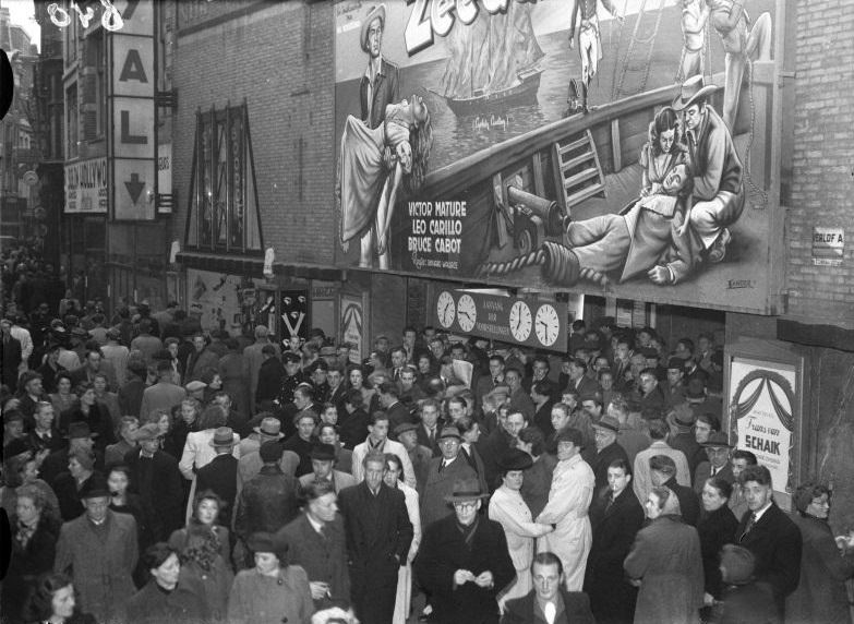 Crowds for the movie Monkfish at cinema Cinema Royal, in the support act the singing wanderer Frans van Schaik, Nieuwendijk. Amsterdam, November 26, 1946