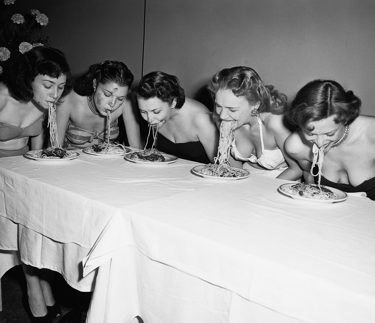 Broadway show girls compete in a hands-free spaghetti-eating contest, 1948.