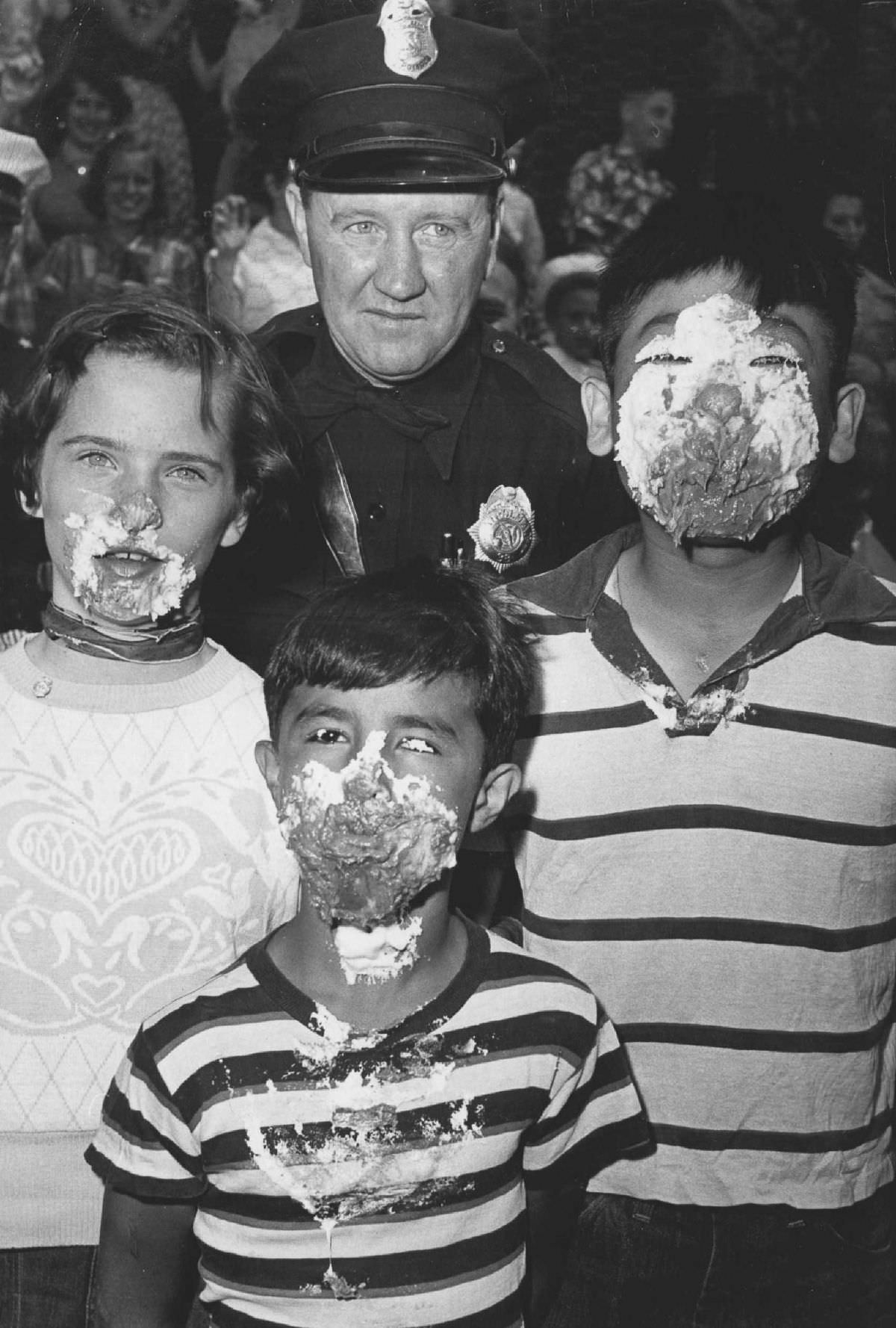 Denver Patrolman Joe Hale poses with the winners of a pie-eating contest, 1954.