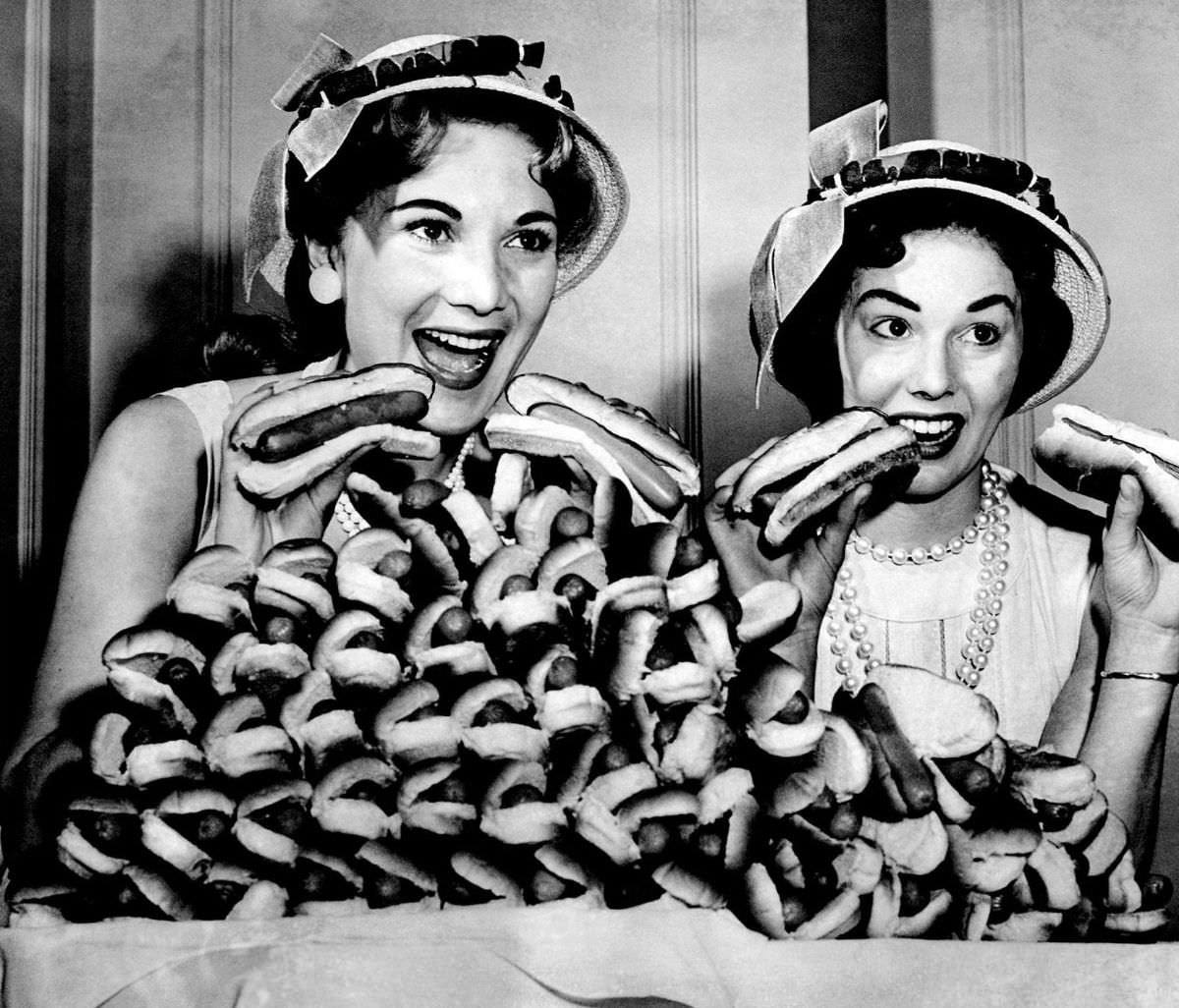 Marion Todd, left, and Marge Kraus during National Hot Dog Month, posing with a plate of 60 hot dogs, which at the time represented what the average American ate in a year in Chicago, 1957.