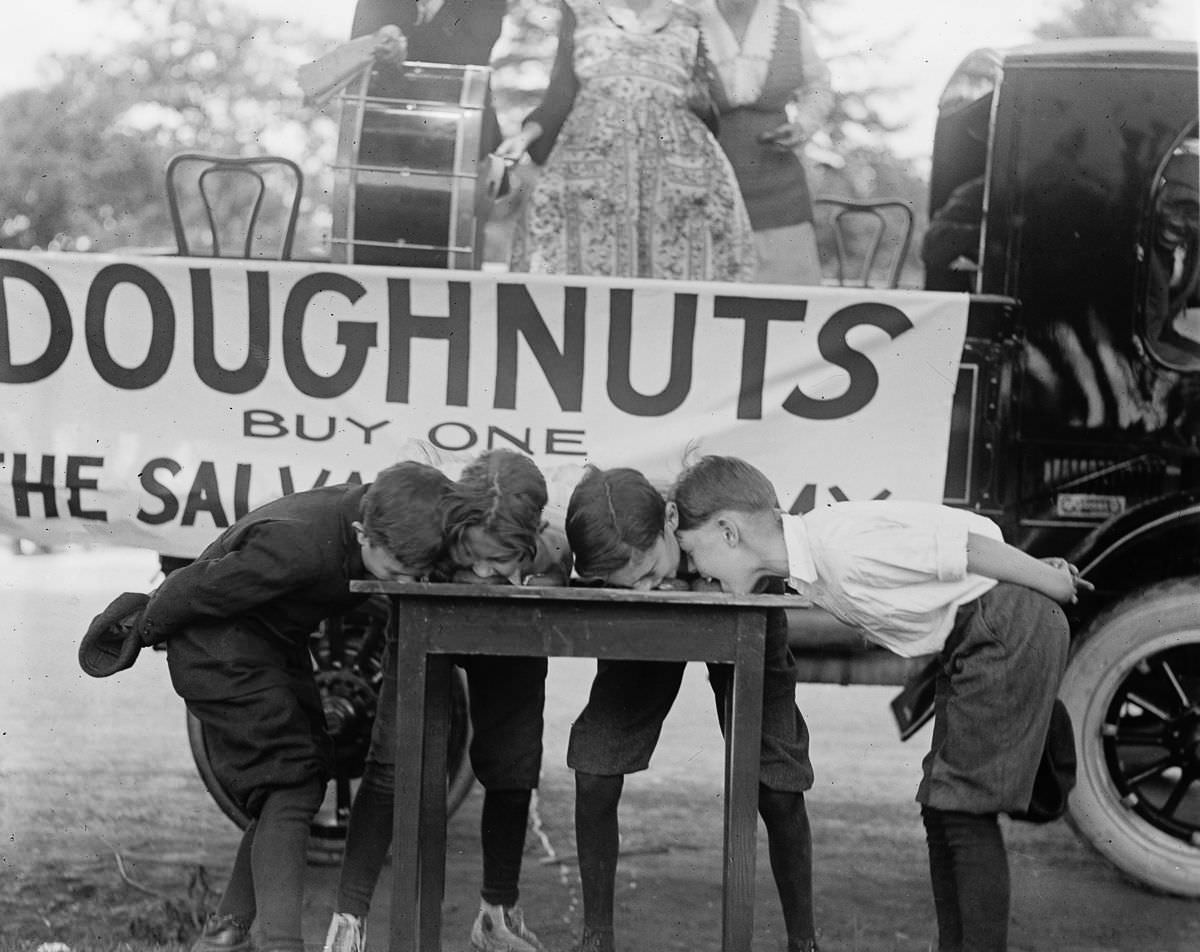 Four youngsters vie for first place during a doughnut eating contest held by the Salvation Army in May, 1922.