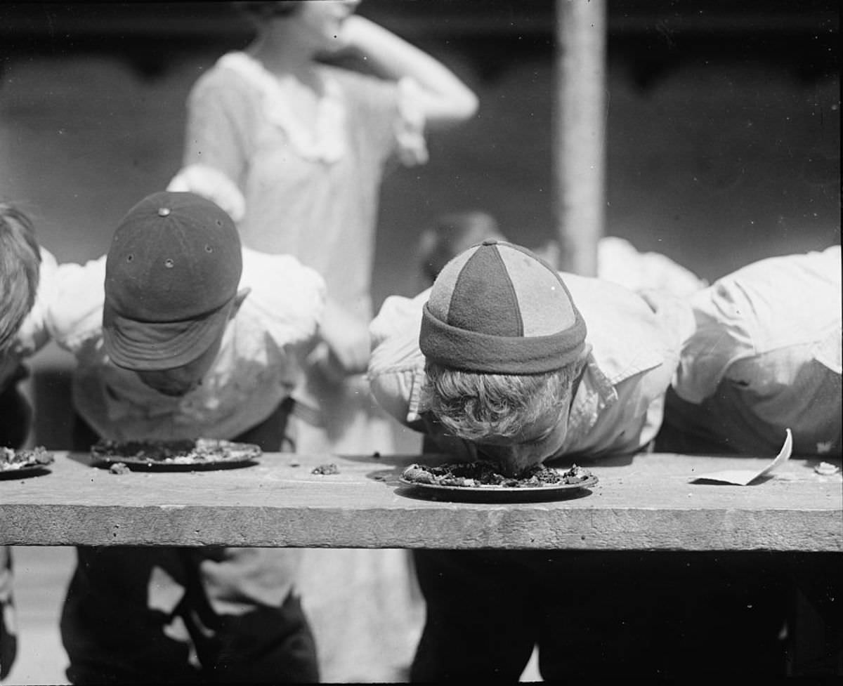 Boys dunk their mouths into pies at Jefferson school, Washington D.C, 1923.