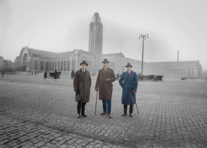 Three gentlemen posing in front of Helsinki's new railways station, 1900s.