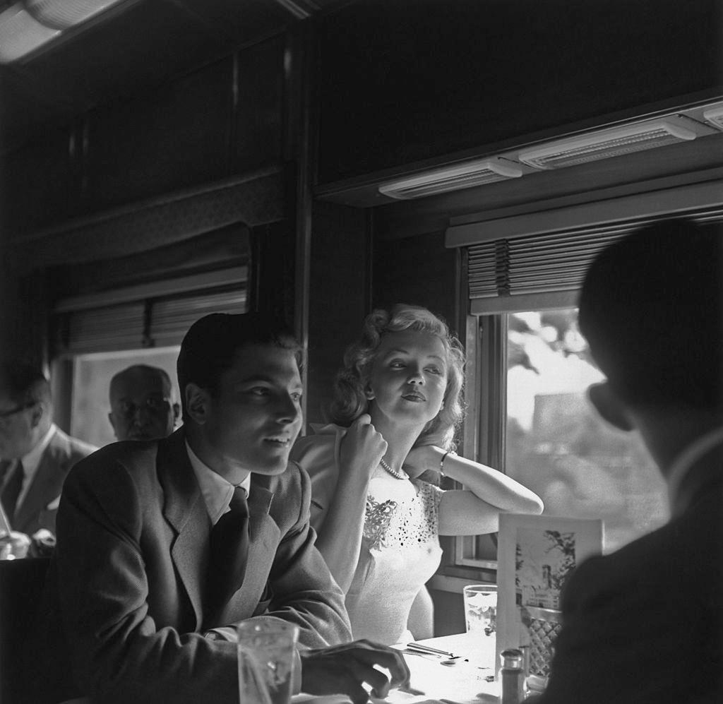 Marilyn Monroe with actor Lon McAllister riding on a train for the promotion of movie 'Love Happy', 1949.