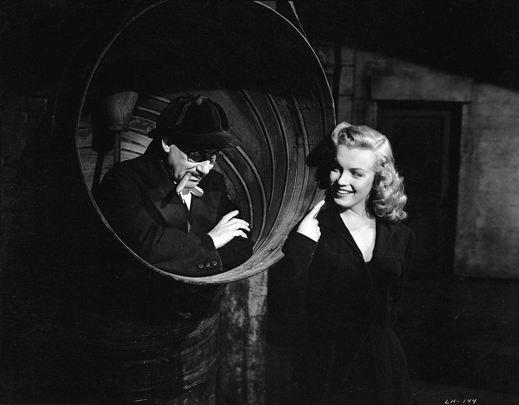 Marilyn Monroe finds Groucho Marx hiding in a ship's funnel in the crime caper 'Love Happy', 1949.