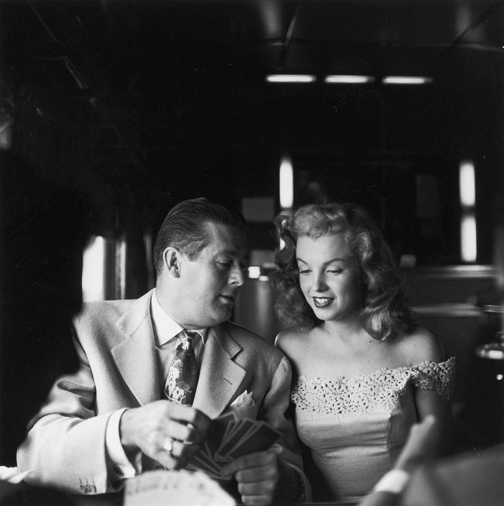 Marilyn Monroe and Don Defore playing cards on a train from New York City to Warrenburg, 1949.