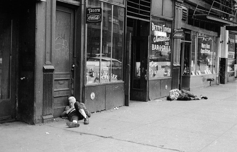 Two drunks asleep on the street outside Betty's Tavern in New York.