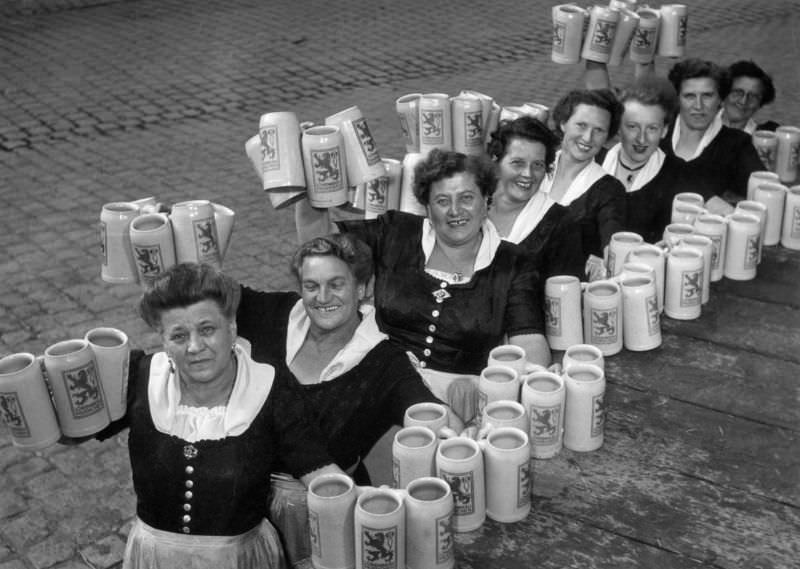 Waitresses showing empty beer litre tankards at the Oktoberfest.