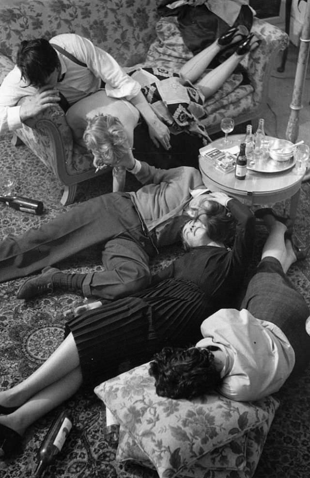 A staged scene of a drunken group of people in a living room.