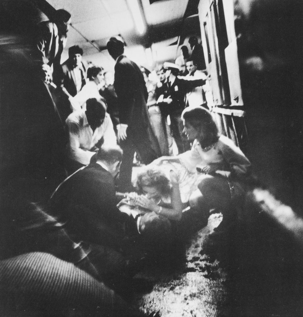 Robert Kennedy lies on the floor after being shot while his wife, Ethel Kennedy, leans over him and other watch.