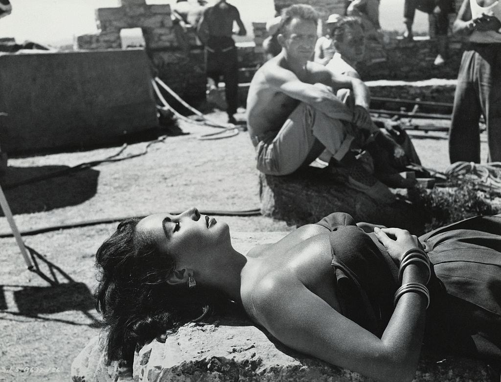 Elizabeth Taylor makes a lovely picture in this candid shot, sunning herself in Spain on location for "Suddenly Last Summer."