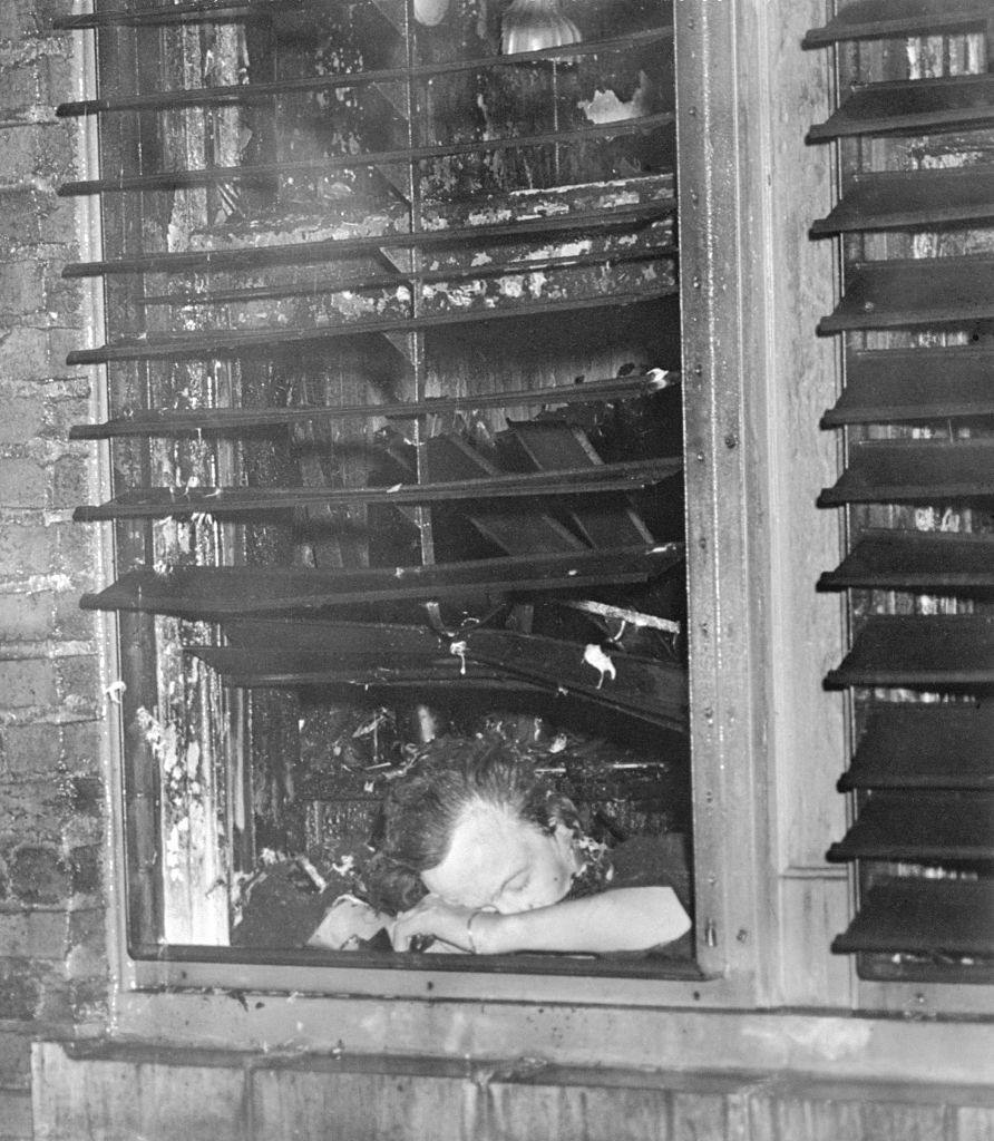 A- The dead body of an unidentified woman lies on the window sill of her room in the Winecoff Hotel, Atlanta, after fire swept the hotel