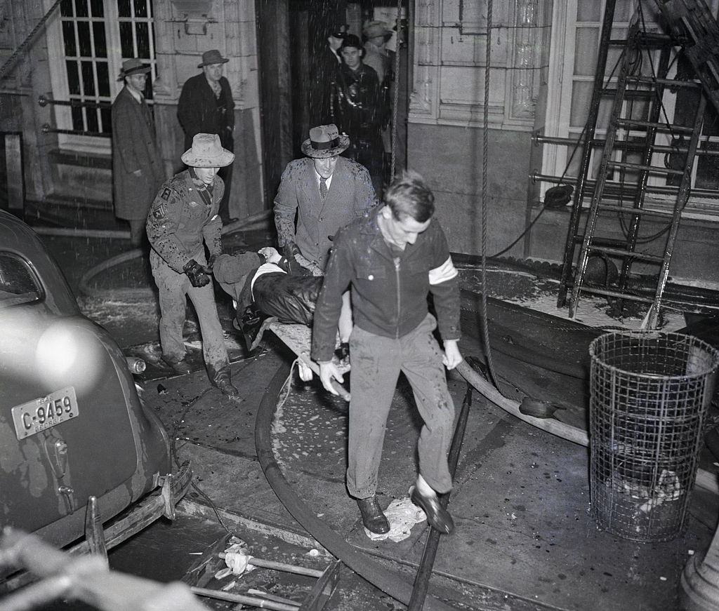 Volunteer rescue workers carry a victim from the Winecoff Hotel in Atlanta.