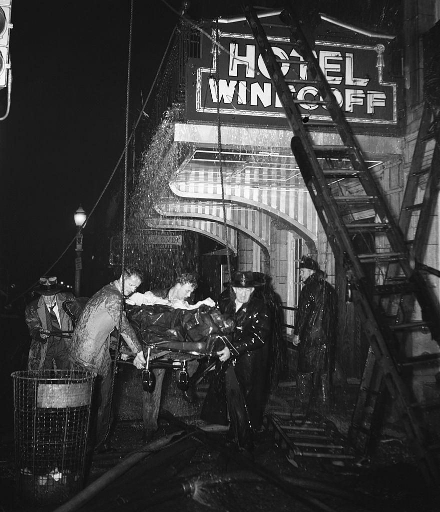 Volunteer rescue workers carry a victim from the Winecoff Hotel in Atlanta.