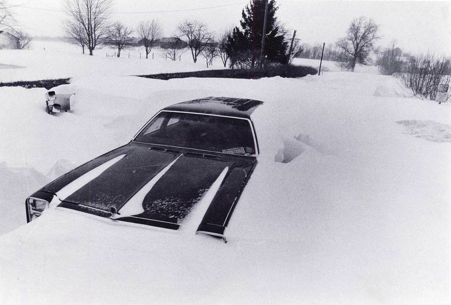 An abandoned car lies buried in a giant snowdrift on Jan. 27, 1978, off Eastern Road near Rittman in Wayne County.