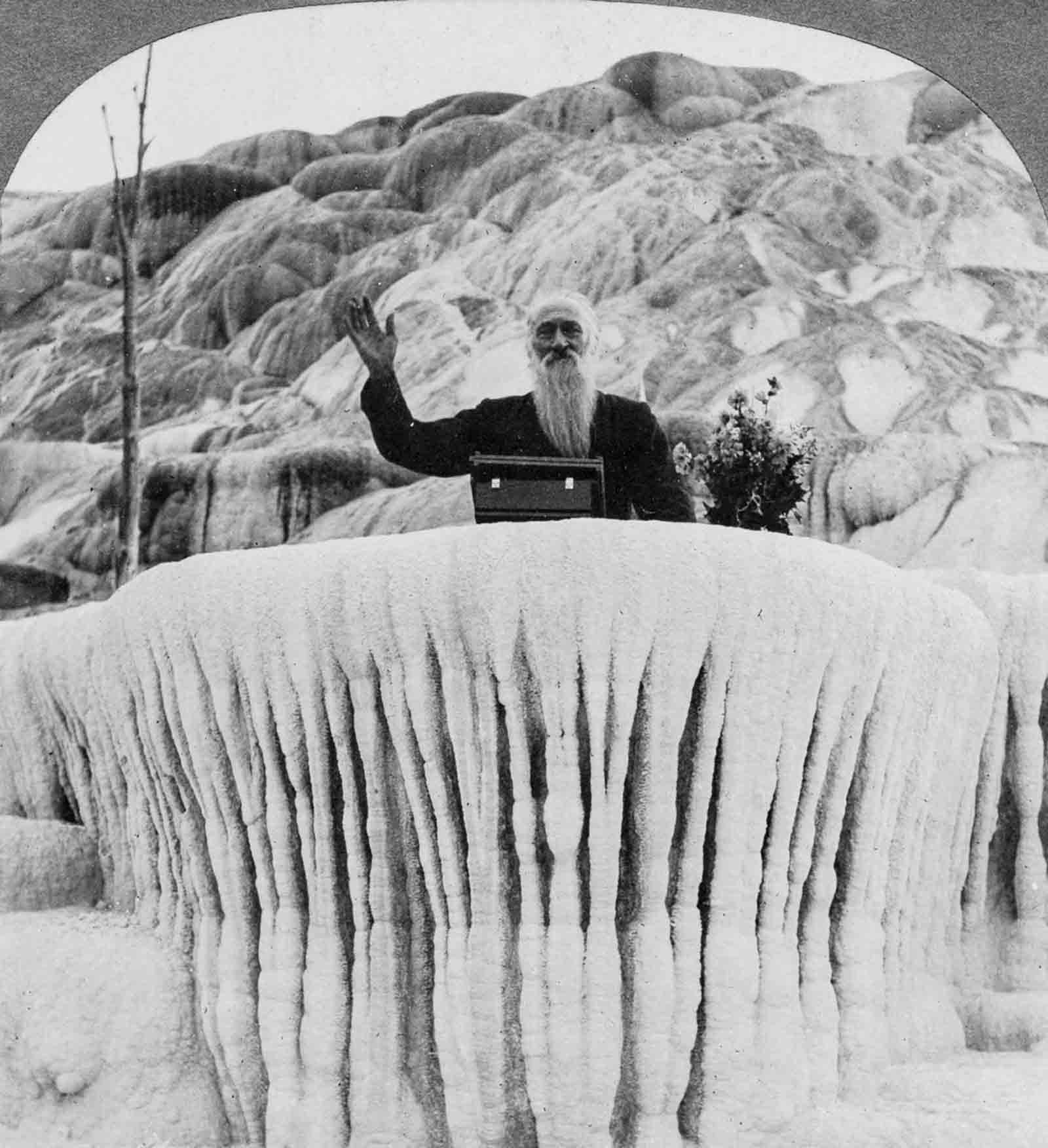 A man stands behind the “Pulpit Terrace” formation at the Mammoth Hot Springs in Yellowstone, 1904.