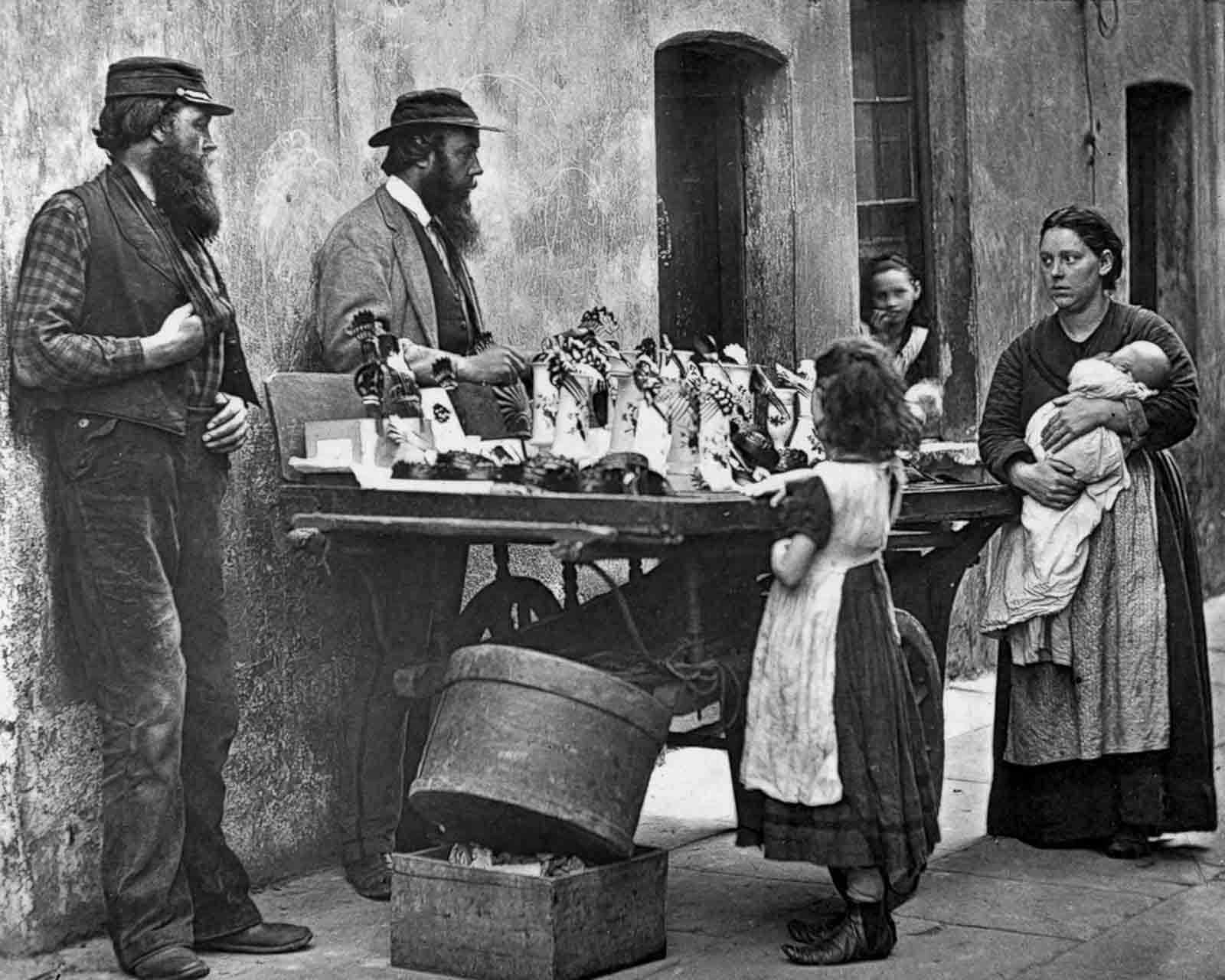 A fancy ware dealer sells ornaments from his barrow, 1877.