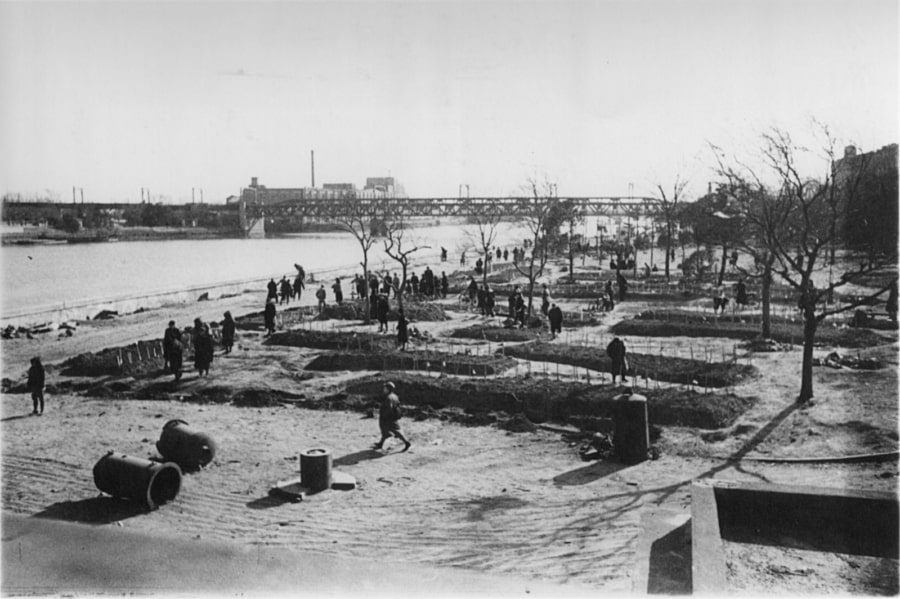 Countless victims of the deadly air raid were buried in mass graves like these along the Sumida River in the Asakusa district. March 19, 1945.