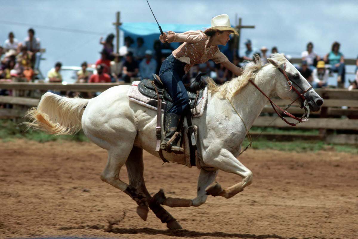 A cowgirl whips her horse to a gallop during the annual rodeo in Princeville, Kauai, Hawaii