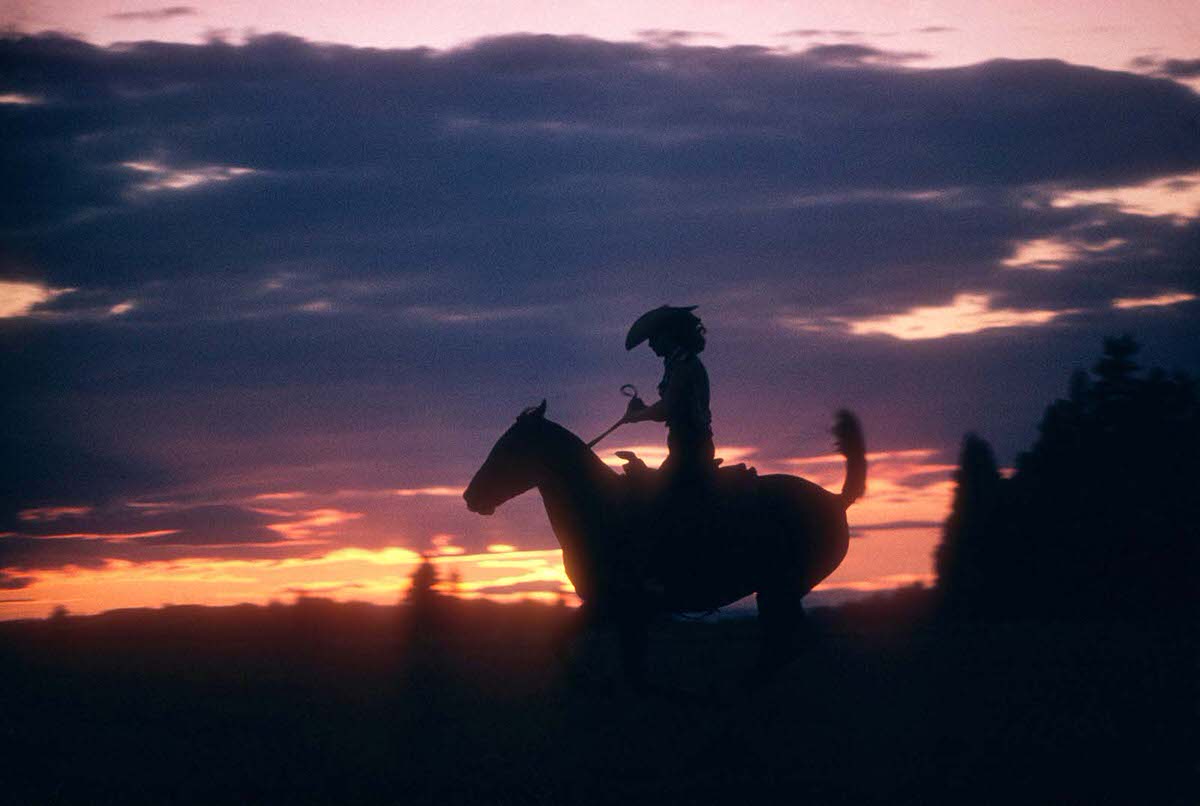 A woman riding before an Oregon sunset in 1958.