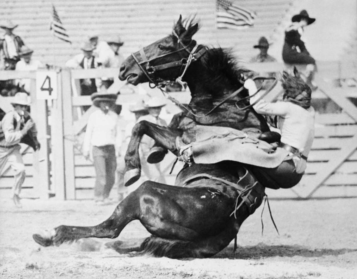 Fox Hastings, a cowgirl and trick rider, being thrown by Undertow, one of the meanest horses at the first annual Los Angeles Rodeo, circa 1920s.