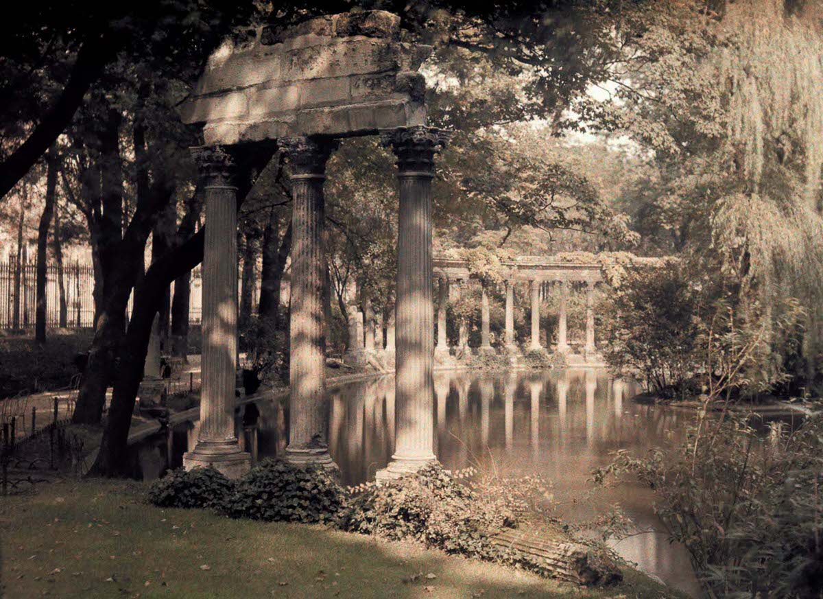 A colonnade and lake in a garden.