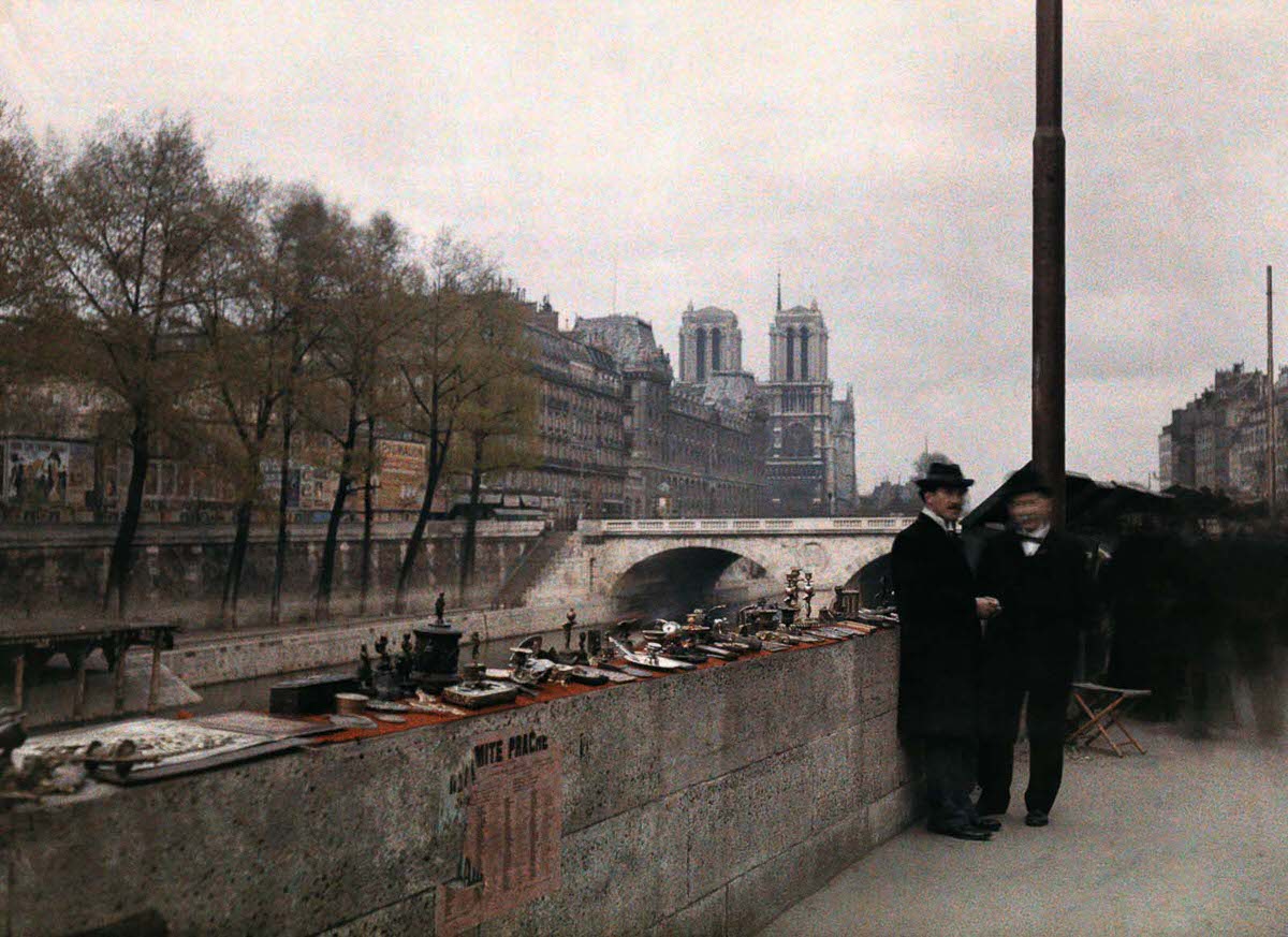 Men stand beside crafts for sale near the cathedral of Notre Dame.