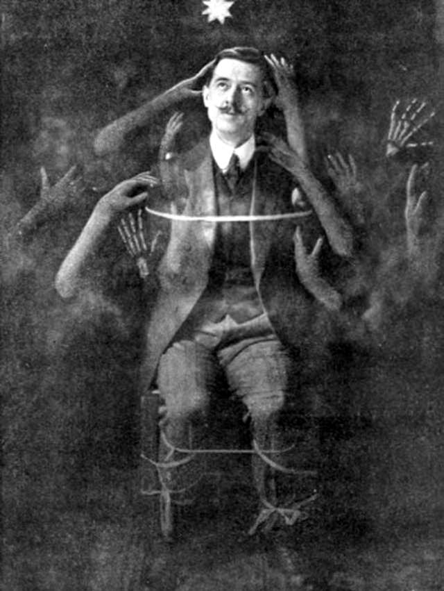 William Marriott demonstrating a method of producing fake “spirit” hands, 1910.