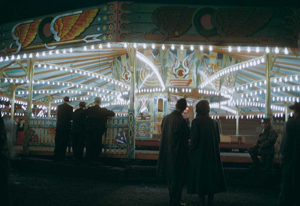 People watching the dodgem cars at night, at Blackpool Pleasure Beach, Blackpool, 1955.