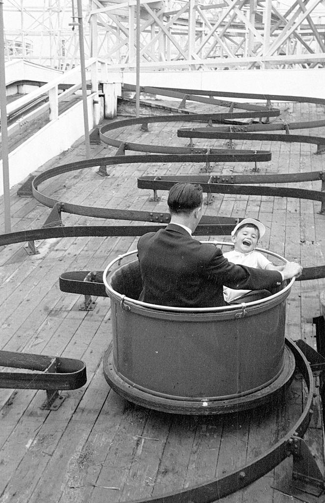 A father and son enjoying a fairground ride on the pleasure beach at Blackpool, 1953.