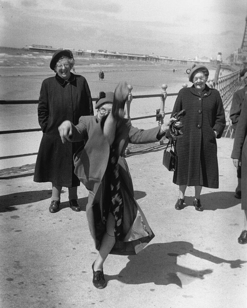 An elderly women performs a high kick on the promenade at Blackpool, 1955